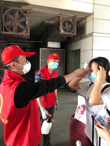 陈孟伟作为接站志愿者为学生测量体温